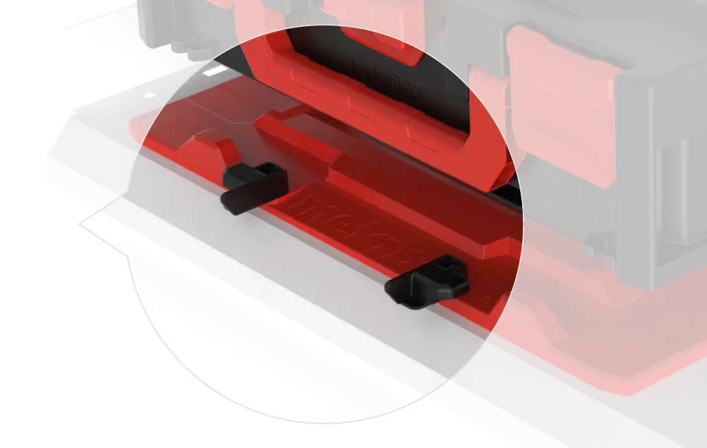 Close-up of a red and black tool component with two small black latch clips on a red base.