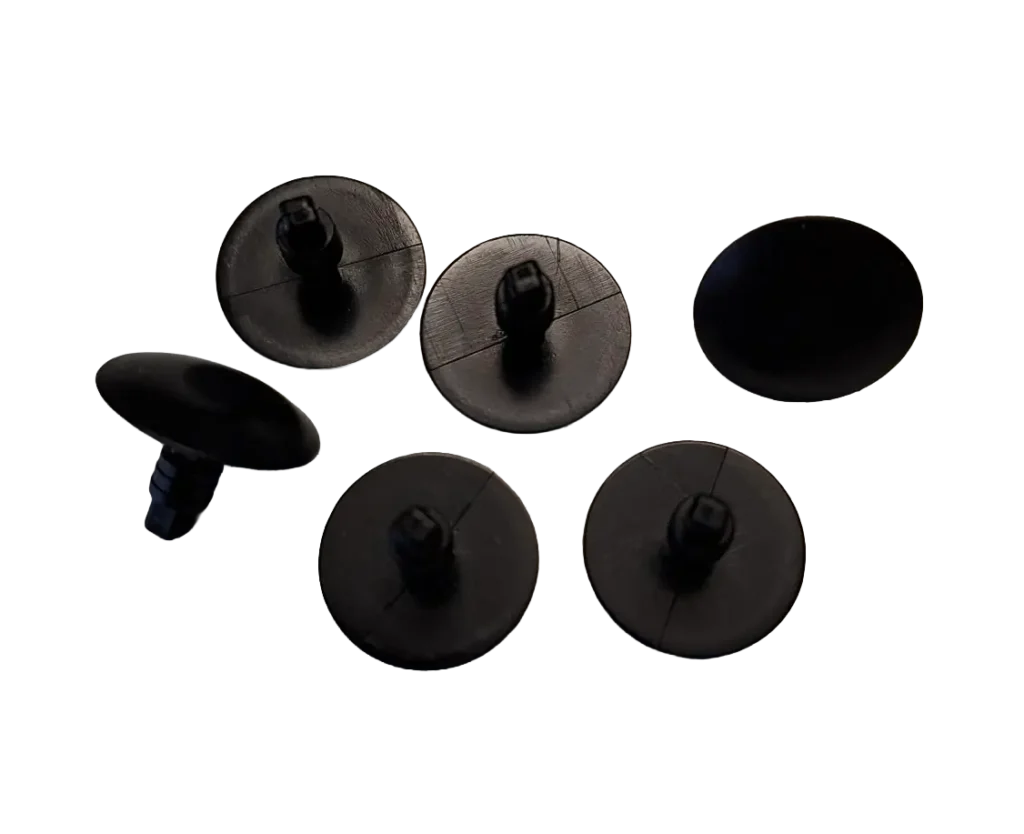Six black round furniture glides with small central pegs arranged on a white background, likely chair leg floor protectors;